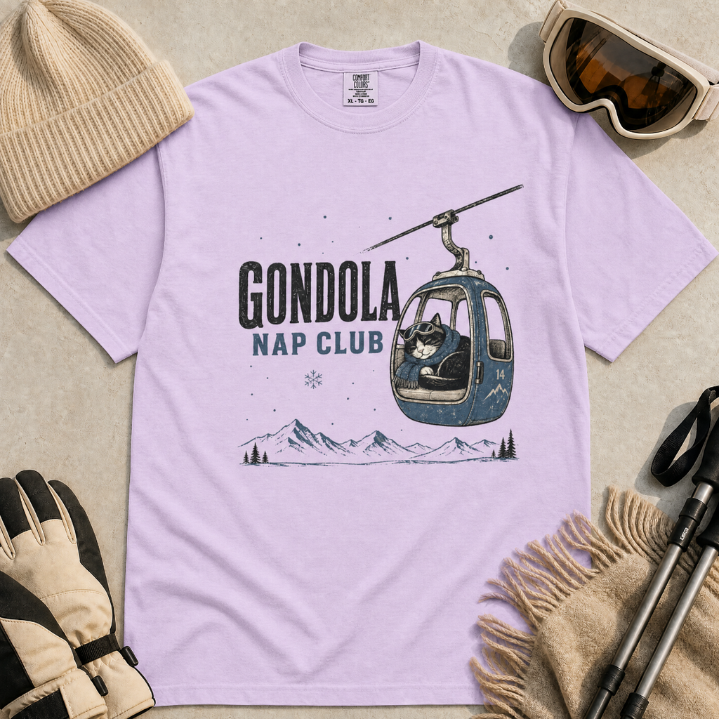 Orchid colored t-shirt featuring a cat napping in a ski gondola with text, "Gondola Nap Club".