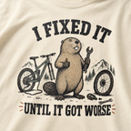 Beaver with a bicycle and tools on a t-shirt with text 'I fixed it until it got worse'.