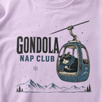 Orchid colored t-shirt featuring a cat napping in a ski gondola with text, "Gondola Nap Club".