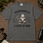 Pepper gray t-shirt featuring a possum meditating while fixing a bike with text, "Maintenance is a State of Mind".