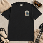 Flat lay of a black t-shirt featuring a small chest “Family Ski Team” badge graphic with three winter animal characters, styled with ski accessories.