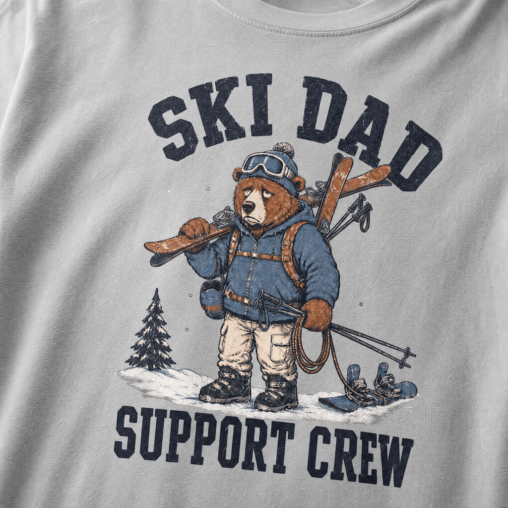 Close-up of a granite gray t-shirt with a vintage ski dad design showing an exhausted bear loaded with skis, poles, and snow gear.