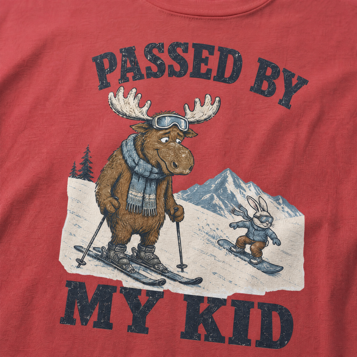 Close-up of a crimson red t-shirt with a vintage “Passed By My Kid” design showing an embarrassed moose skier being passed by a tiny rabbit snowboarder.