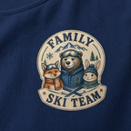 Close-up of a navy t-shirt with a retro badge design showing a bear, fox, and rabbit as a “Family Ski Team.”