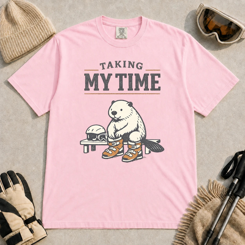 Blossom tee featuring a relaxed beaver sitting on a bench in ski boots beside a helmet and goggles, with the phrase “Taking My Time.”