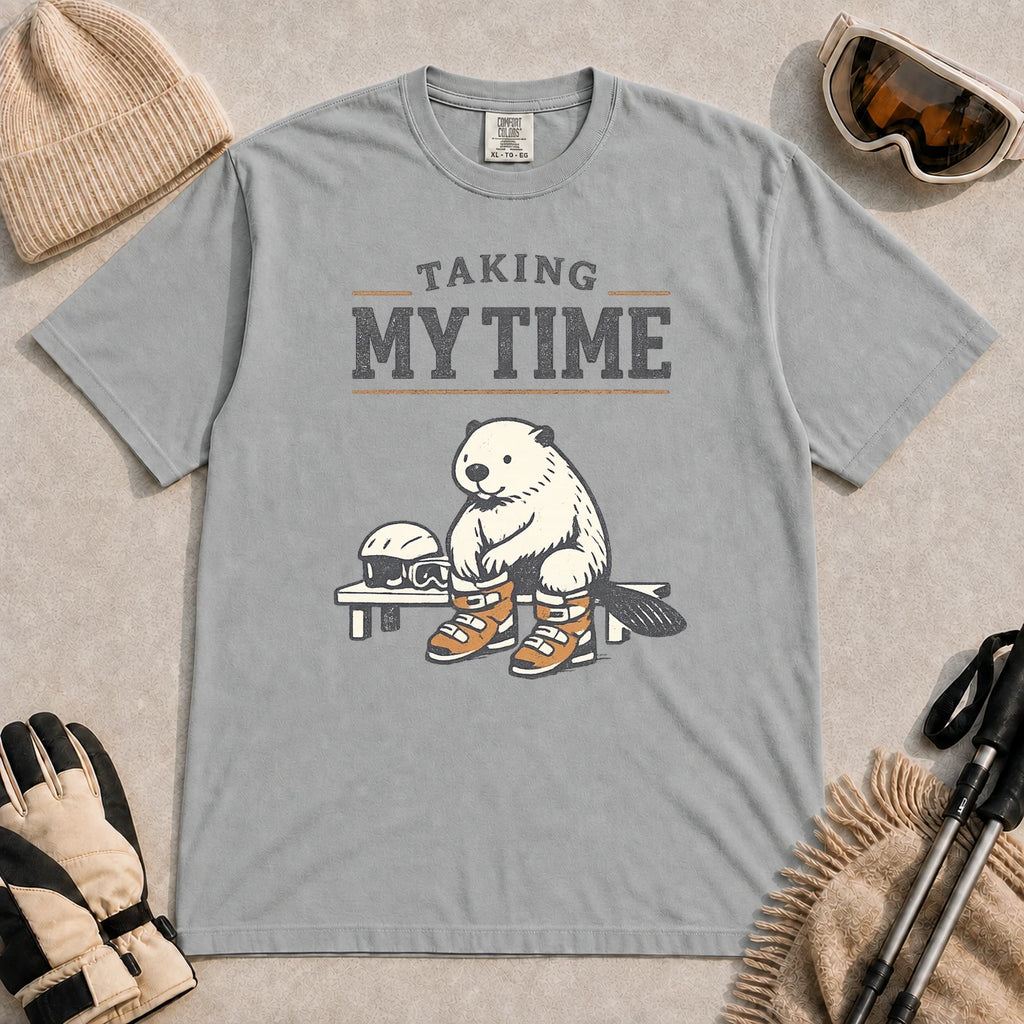 Granite tee featuring a relaxed beaver sitting on a bench in ski boots beside a helmet and goggles, with the phrase “Taking My Time.”