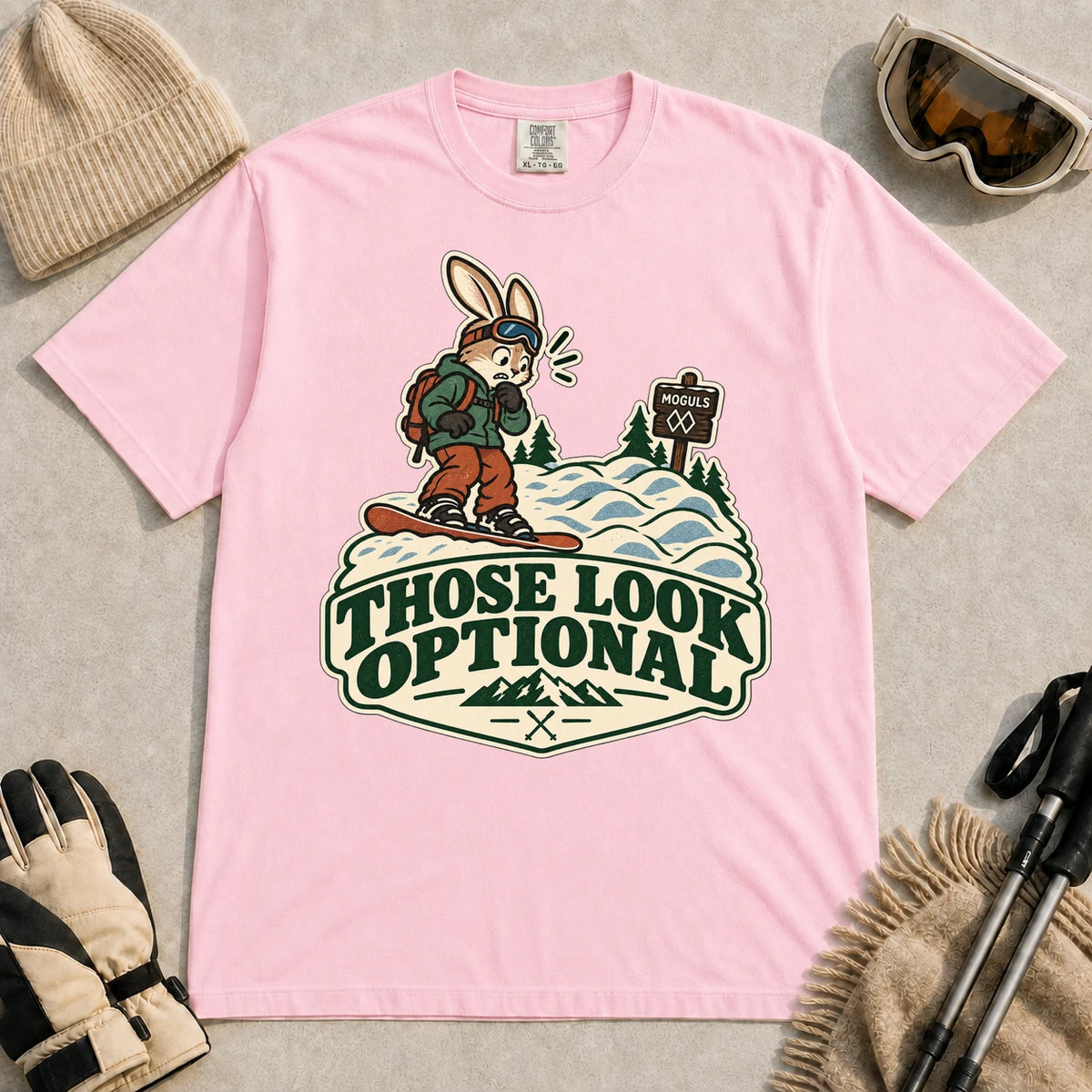 Blossom tee featuring a cautious bunny snowboarder facing a mogul run beside a “Moguls” sign above the phrase “Those Look Optional.”