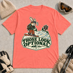 Coral Silk tee featuring a cautious bunny snowboarder facing a mogul run beside a “Moguls” sign above the phrase “Those Look Optional.”