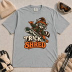 Granite tee featuring a raccoon snowboarding in Halloween gear and a witch hat above the phrase “Trick or Shred.”