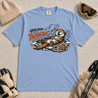 Washed Denim tee featuring a relaxed otter thawing in a warm mountain hot spring beside ski goggles and a beanie, with the phrase “Very Busy Thawing.”