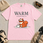 Blossom tee featuring a chilly squirrel in ski goggles warming its paws beside a steaming mug in the snow, with the phrase “Warm Eventually.”