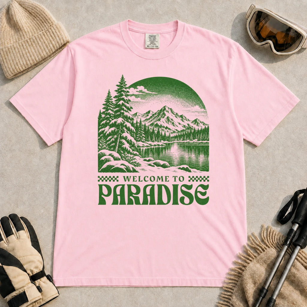 Blossom tee featuring a green vintage mountain lake and evergreen forest scene with the phrase “Welcome to Paradise.”