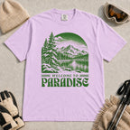 Orchid tee featuring a green vintage mountain lake and evergreen forest scene with the phrase “Welcome to Paradise.”