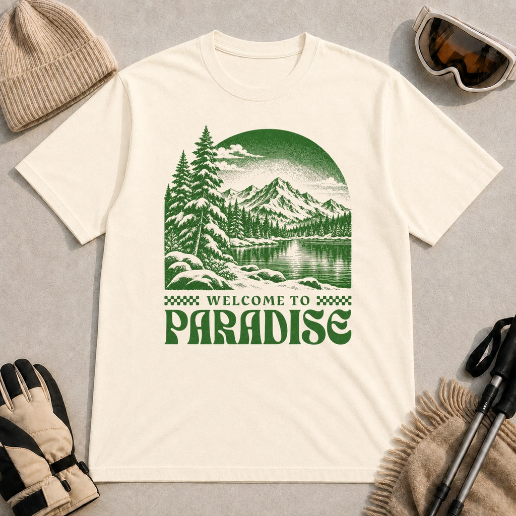 Natural tee featuring a green vintage mountain lake and evergreen forest scene with the phrase “Welcome to Paradise.”