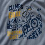 T-shirt with graphic of a goat riding a bike and text 'Climbs like a goat, descends like a shopping cart' on a gray background.