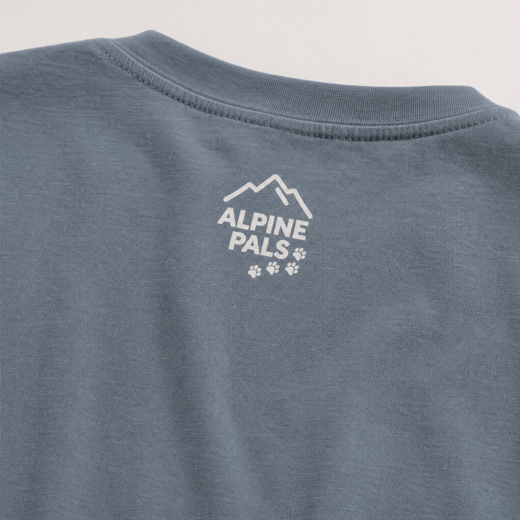 Blue jean colored shirt with 'Alpine Pals' logo on a light gray background