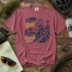 Brick colored t-shirt with mountain bike graphic and text on a wooden surface with cycling accessories.
