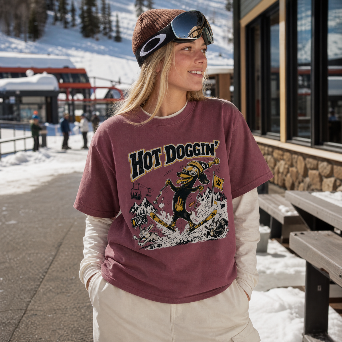 Person wearing a 'Hot Doggin' t-shirt in a snowy outdoor setting