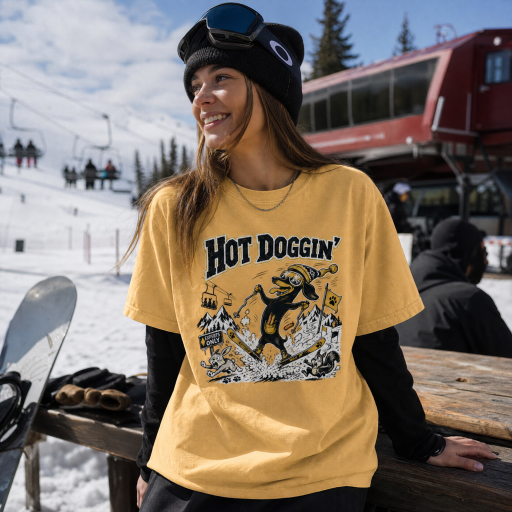 Person wearing a yellow 'Hot Doggin' t-shirt at a snowy location
