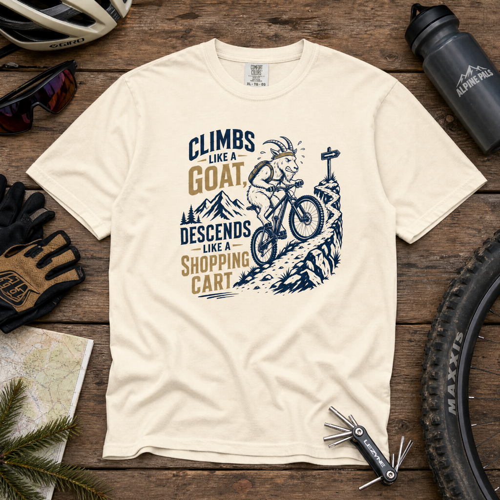 Ivory colored t-shirt with graphic design and text on a wooden surface with cycling accessories.