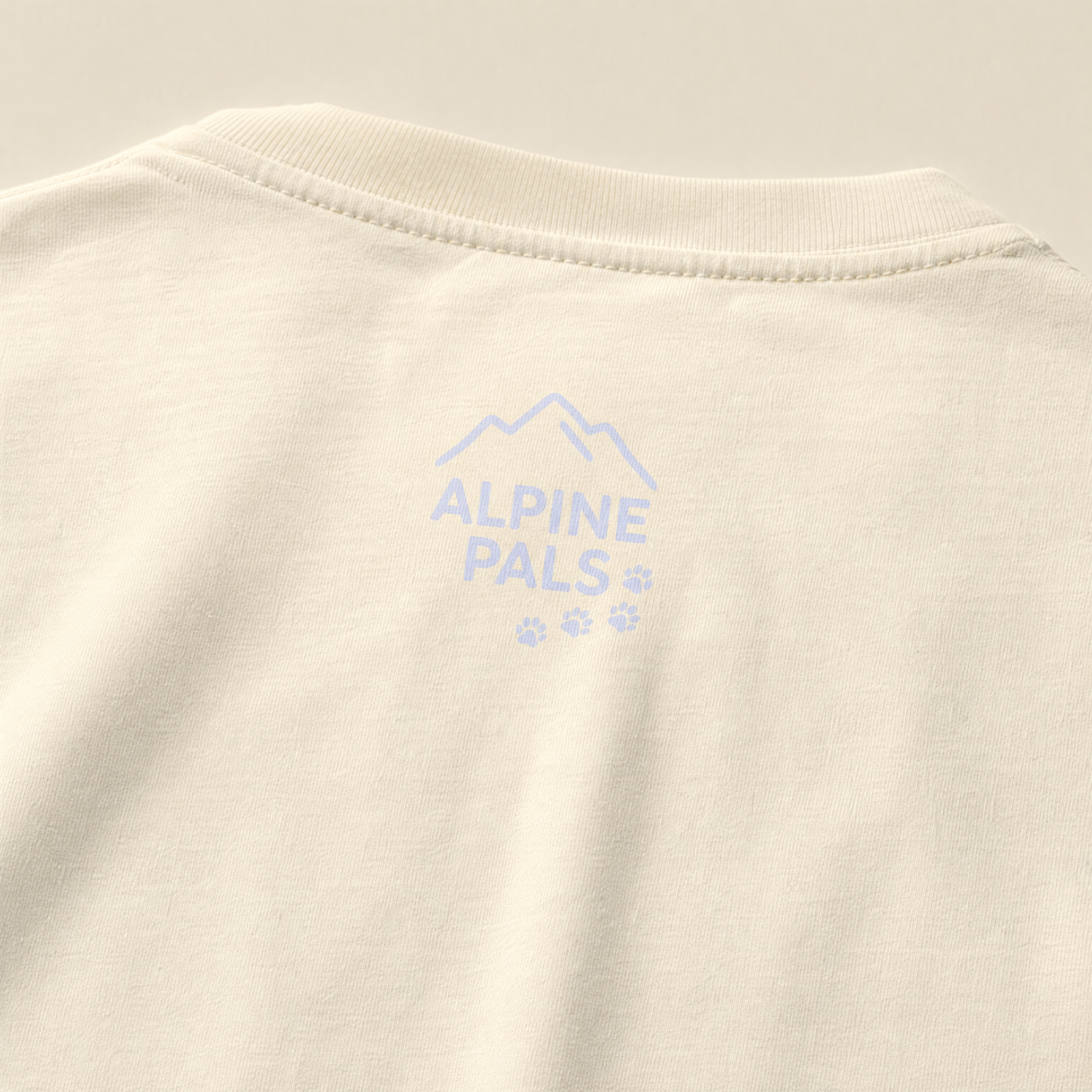 Beige fabric with 'Alpine Pals' logo embroidered on it