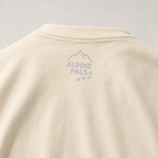 Ivory colored shirt with 'Alpine Pals' logo on a gray background