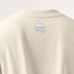 Ivory shirt with 'Alpine Pals' logo on a light gray background
