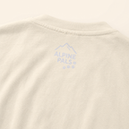 Close-up of a beige fabric with 'Alpine Pals' logo embroidered on it.