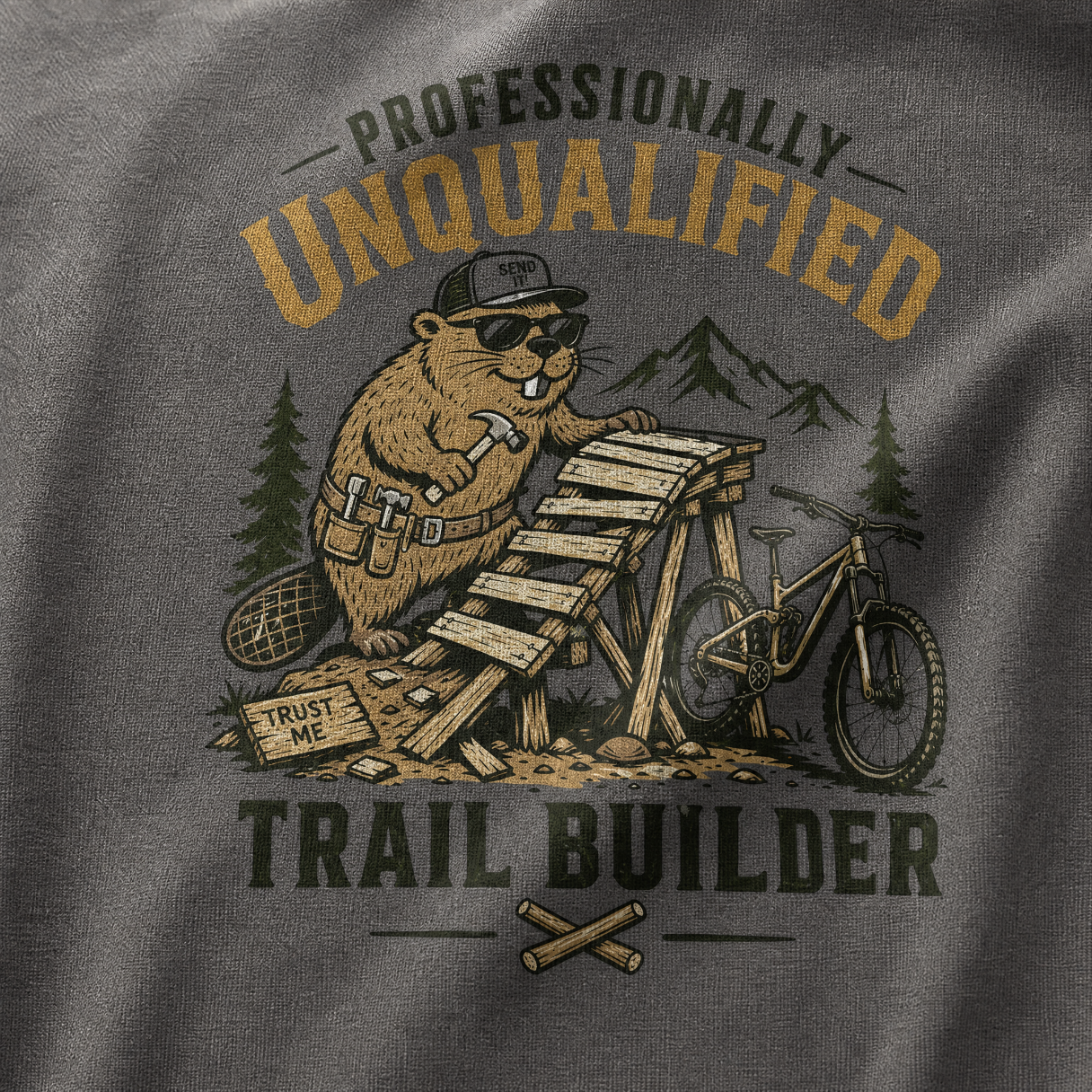 T-shirt with a beaver graphic and text 'Professionally Unqualified Trail Builder' on a gray background.
