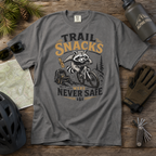 Pepper gray t-shirt with a raccoon graphic and text on a wooden surface with outdoor gear.