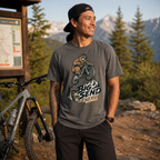 Man wearing a t-shirt with a bear graphic and 'Big Send Energy' text, standing in a mountainous area.