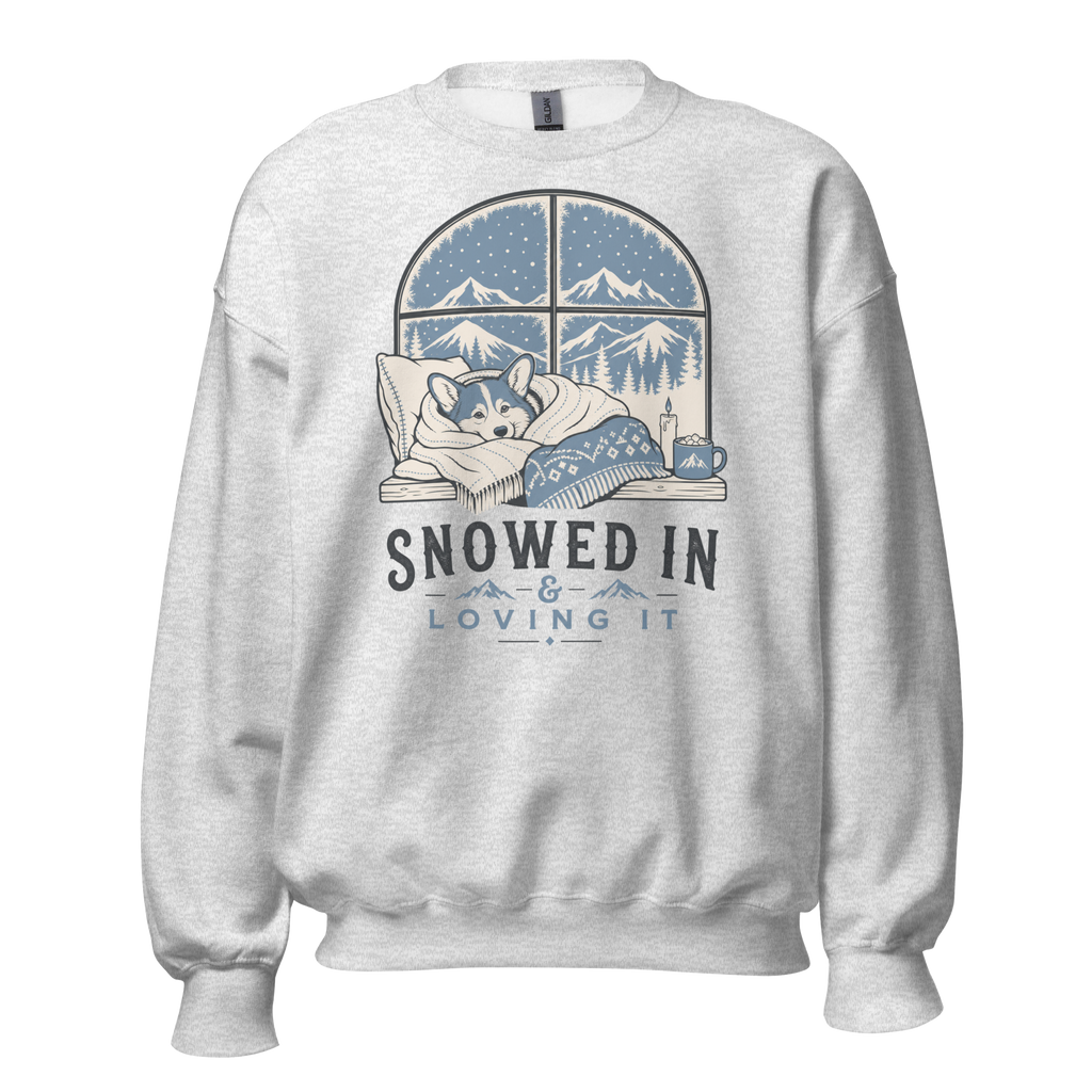 Ash gray sweatshirt with a graphic of a dog by a window and 'Snowed In & Loving It' text on a white background