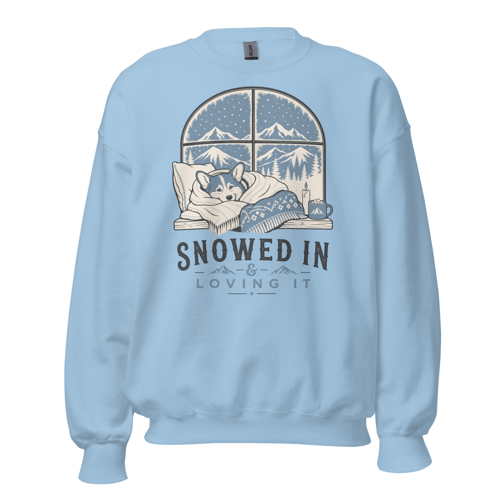 Light blue sweatshirt with a graphic of a dog by a window and 'Snowed In Loving It' text on a white background.