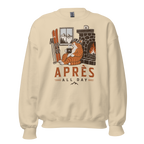 Sand colored sweatshirt with a graphic of a cat by a fireplace and skis, with 'APRES ALL DAY' text.